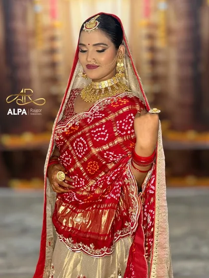 This pose showcases the rich detail of the bridal outfit and jewelry. The makeup features soft, shimmering eyes and a defined lip to complete the traditional aesthetic.