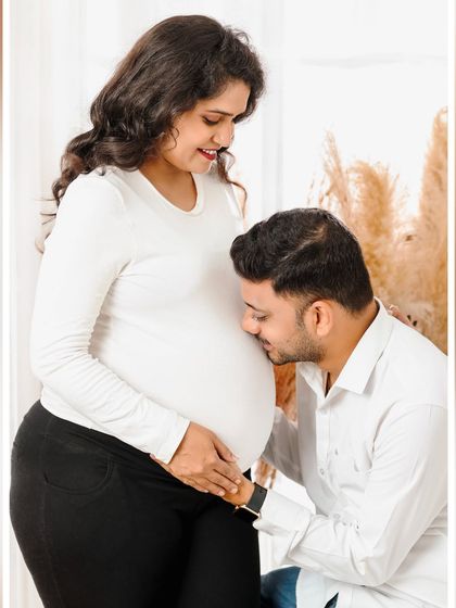 A classic pose in maternity photography, with the father-to-be affectionately kissing the baby bump. This shot beautifully captures his love and connection with his unborn child in a simple, heartfelt way.