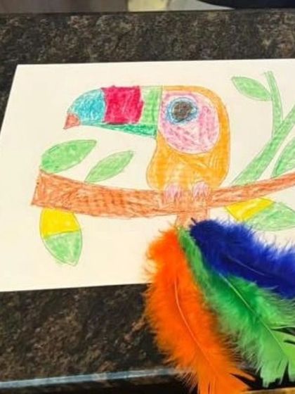 A colorful toucan artwork made with paper and feathers by a camper during our Dusshera Camp. This shows how we mix different materials to make art more engaging.