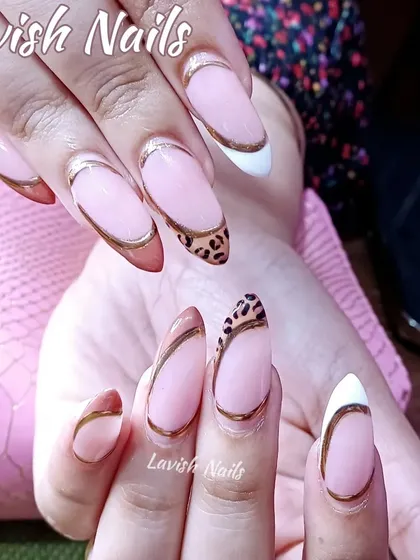 A modern twist on the French manicure, these almond-shaped nails feature a sharp design with gold chrome outlines, a classic white tip, and a bold leopard print accent nail. This look combines multiple techniques for a trendy, high-fashion result.