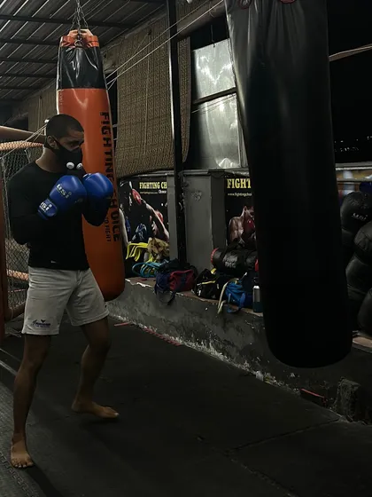 A fighter holds a solid boxing stance while training on the heavy bag. Proper stance is the foundation for both powerful offense and effective defense.