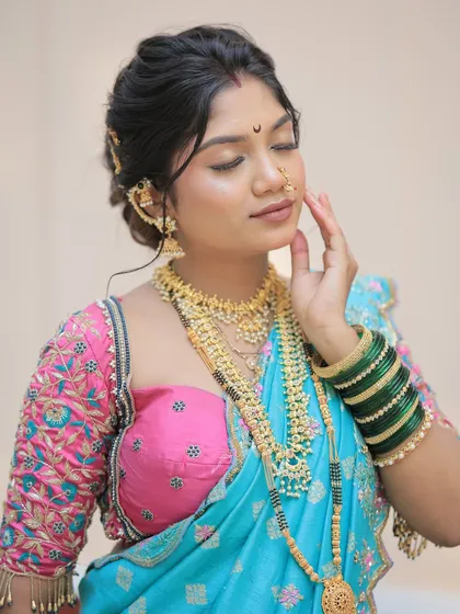 A serene close up of the Gudi Padwa look. The makeup is soft and glowing, with a focus on flawless skin, complemented by traditional gold jewelry and a Chandrakor bindi.