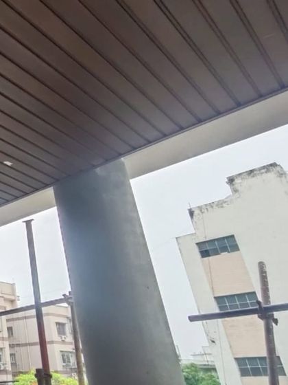 A dark wood-finish ceiling installed on a balcony. This demonstrates a practical application, providing a finished look that is resistant to the elements.