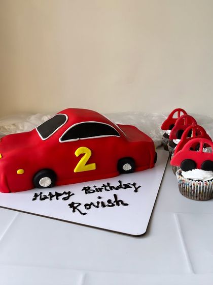 A final look at the red car cake and matching cupcakes. This is a great option for a kid's birthday party, combining a main cake with easy-to-serve treats.