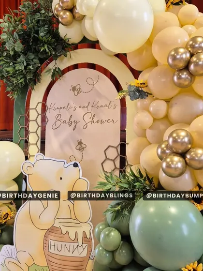 A close-up of a Winnie the Pooh baby shower theme, featuring a "Hunny" pot and honeycomb details. The soft yellow and green balloons create a warm and gentle atmosphere.