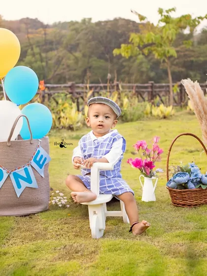 A charming portrait of a little boy on his wooden tricycle, part of our rustic-themed first birthday prop collection for outdoor shoots.