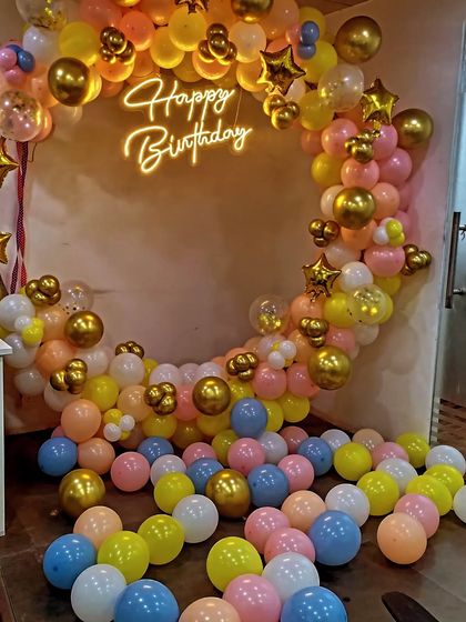 A colorful and playful balloon ring decoration. The pastel-colored balloons are scattered on the floor and arranged around the ring, creating a fun and festive atmosphere.