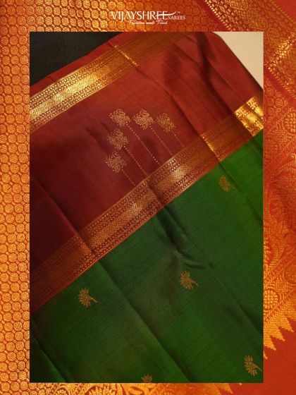 A classic combination of deep maroon and bottle green in a hand-woven Kanjivaram. The delicate floral buttis and traditional gold zari border make this a heritage piece.