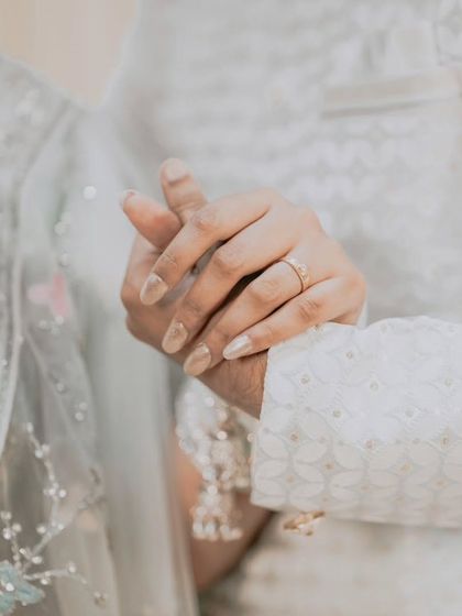 A simple, elegant shot of the couple holding hands after the ceremony. This photo highlights the bride's ring and the quiet connection between them.