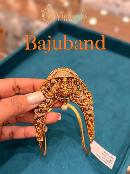 A close-up of a temple bajuband with Navratna stones surrounding the Lakshmi motif. The multi-color stones make it easy to pair with different silk sarees.