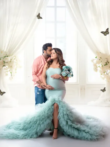 A glamorous maternity portrait for an expecting couple. The flowing sea-green gown and ethereal white drapes create a magical, romantic setting to celebrate the miracle of life.