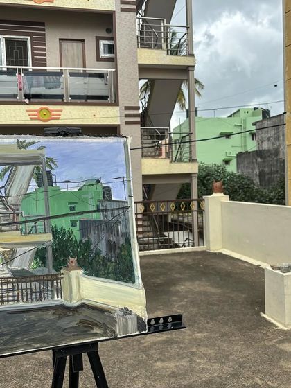 Another angle of my rooftop painting, showing the finished artwork on the easel against the building that inspired it.