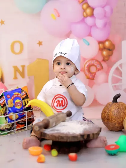 Celebrating a first birthday with a 'Little Chef' theme. This creative setup includes a chef's hat, a basket of snacks, and a playful baking scene.