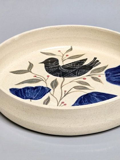 This hand-painted plate, featuring a bird among blue flowers, has found its new home. Each piece I create is a unique work of art, designed to bring enduring appeal to your environment.