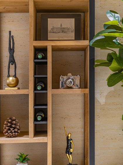 A detailed shot of the curated decor on the director's shelf. Each object was chosen to reflect a sense of sophistication and personality, from the sculptural figures to the framed architectural sketch.