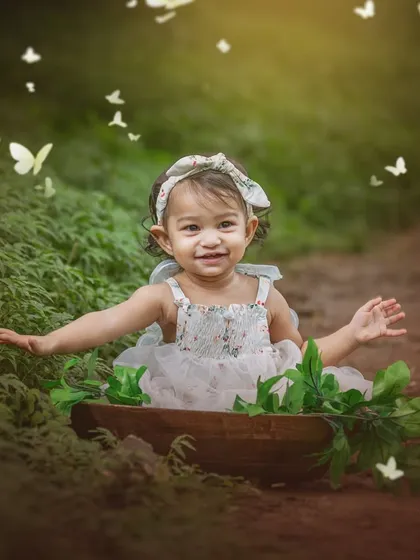 Surrounded by a whirlwind of butterflies, this little girl smiles with pure delight. This image is all about capturing the magic and wonder of childhood.