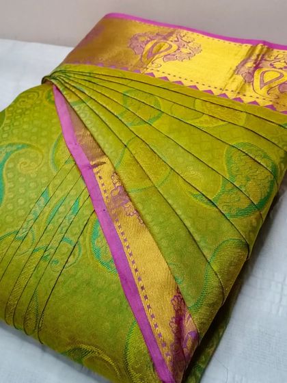 A bright green and pink saree, pleated to perfection. Drape your sarees like a pro in less than five minutes with my service.