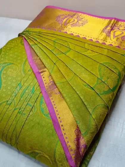A parrot green and pink silk saree, pleated and ready to go.