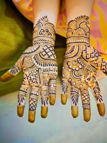 A clear shot of the "Vishal" mehandi with the henna paste still fresh, showing the precision of the lettering.