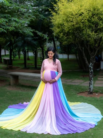 A full-length view of the beautiful rainbow gown, spread out on the grass in a lovely park setting. This shot showcases the dress in all its colorful glory.