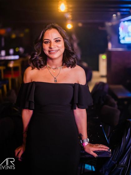 A guest in a stylish off-the-shoulder black dress.