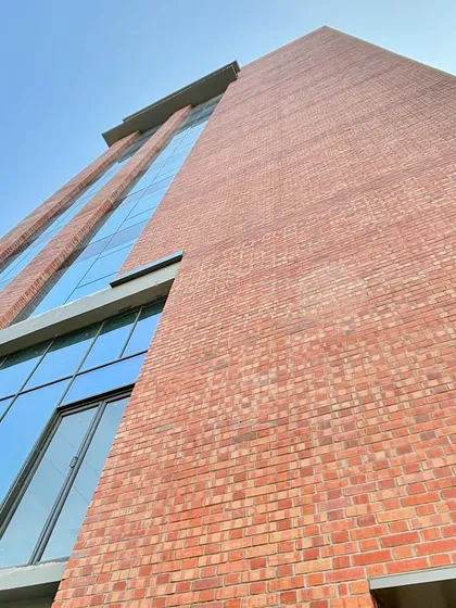 A low-angle shot of the completed brick and glass facade. This perspective emphasizes the verticality of the building and offers a clean, finished look at the material combination we envisioned from the start.