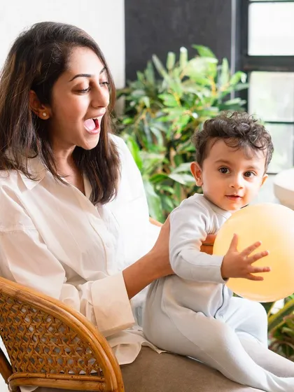 A mother's surprised expression and her child's happy face make for a perfect candid moment. Home sessions are full of these genuine, unposed interactions.