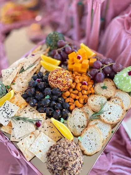 A beautiful cheese and cracker board from the engagement party, featuring artisanal cheese balls, fresh fruits, and a variety of crackers.