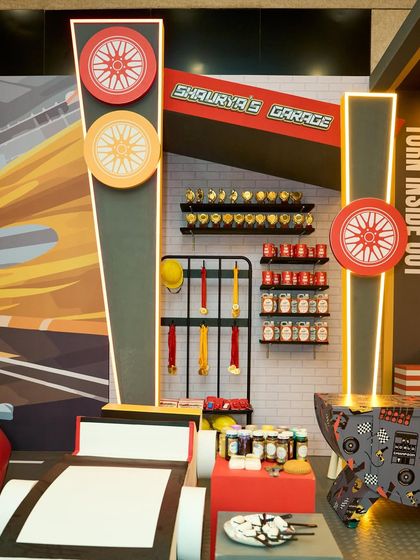 The "Shaurya's Garage" corner featured shelves stocked with custom-labeled props like trophies, medals, and racing gear, adding authenticity to the theme.