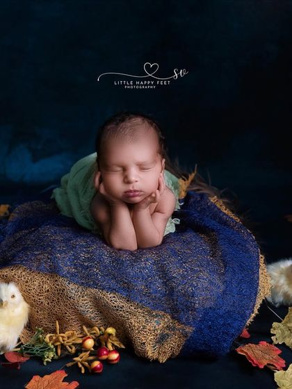 Another beautiful froggy pose, this time with an autumn theme. The baby is surrounded by fall leaves and tiny chicks, creating a whimsical and seasonal portrait.