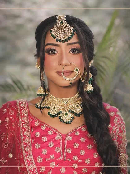 A close-up on bridal beauty. This look features a stunning pink lehenga paired with a Kundan and green bead jewellery set, perfect for a radiant bridal glow.
