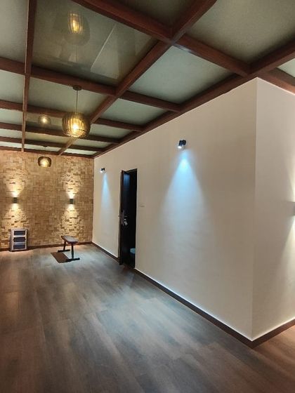 A full view of the completed sunroom or enclosed media room. The dark wood flooring provides a rich contrast to the white walls, while the exposed beam ceiling adds architectural character.