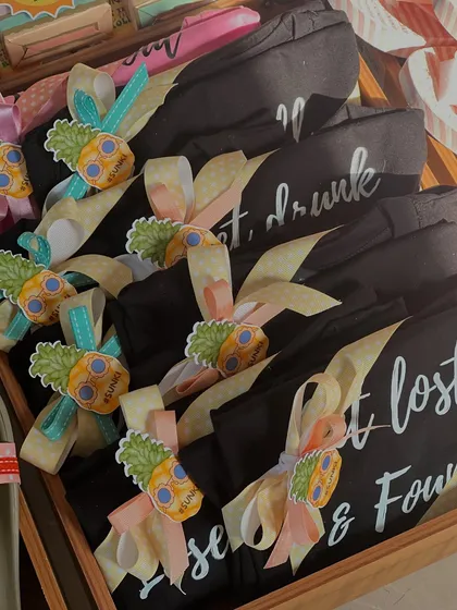"Get lost, drunk & found". These fun, custom-printed t-shirts with pineapple tags were a highlight of the beach bachelorette hampers, adding a playful touch to the celebration.