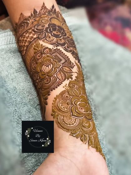 A close-up of a single arm, showcasing a dense and intricate design that combines floral and geometric patterns.