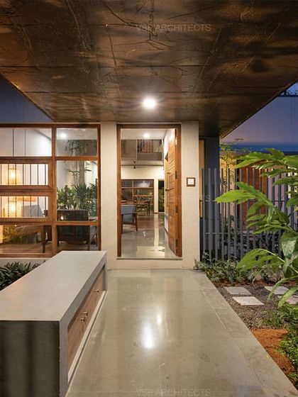 The approach to the 'HAVEN' residence reveals a modern aesthetic with clean lines, concrete finishes, and large wooden-framed windows that hint at the light-filled interiors.