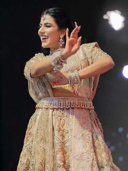 This bride's solo was a beautiful display of grace and traditional dance moves, performed with backup dancers and props against a Sufi-themed backdrop.