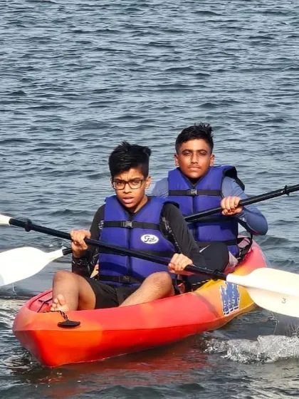 Two participants share a tandem kayak, synchronizing their paddle strokes. This is a great way to learn about communication and teamwork on the water.