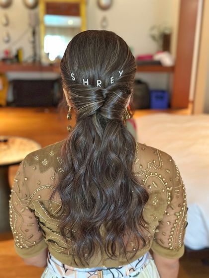A closer look at the twisted detail at the base of the low ponytail, adding a touch of elegance to the textured style.