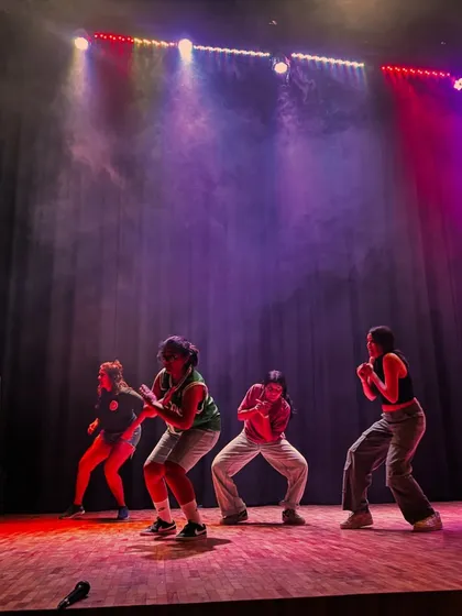 Dancers in position under the vibrant stage lights, focused and ready to begin their routine. This is the moment where practice turns into performance.