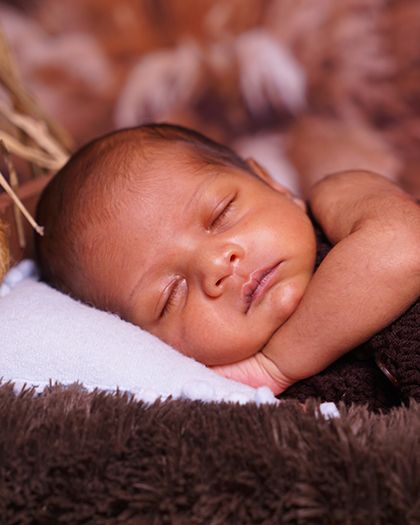 Another angle of the sleeping newborn, showing his sweet, dreaming face. These are the moments parents cherish forever.