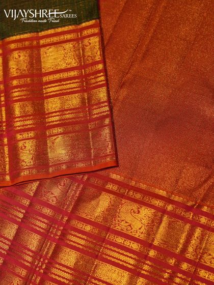 A close-up of the rich red border against the green body, highlighting the intricate gold zari checks.