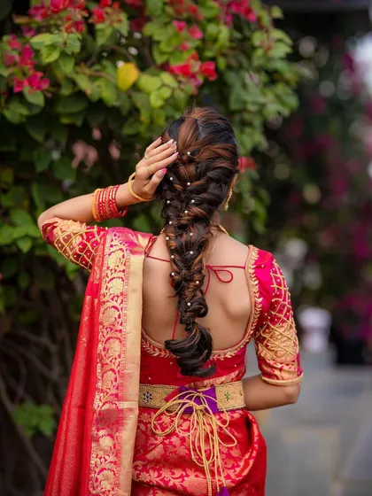 A stunning and intricate bridal braid, woven with pearls. This hairstyle is perfect for a South Indian bridal look or for any bride who wants a unique and elegant style.