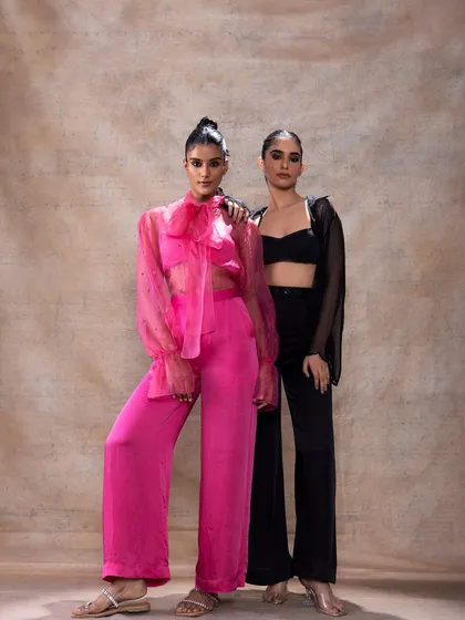 A full-length shot of two models in contrasting modern outfits. Their makeup is coordinated to be sleek and contemporary, showing my versatility in creating looks for different styles, from bold pink to classic black.