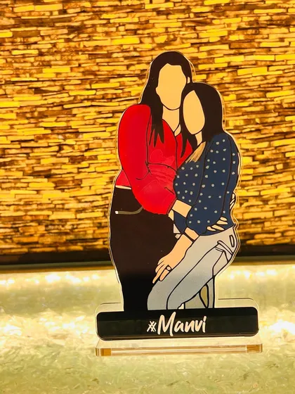 Another look at the 'Manvi' acrylic standee against a warm, textured background. The faceless illustration style focuses on the connection and pose, making it universally relatable.