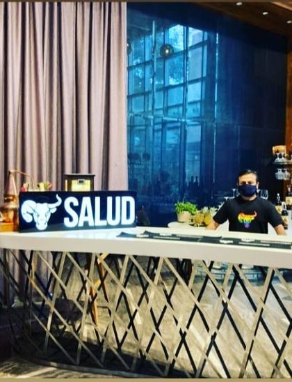 A sleek and modern bar setup for a Salud brand event. The geometric design of the counter combined with simple, bold branding creates a contemporary look suitable for corporate settings.
