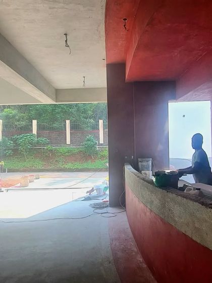 A silhouette of a worker against an opening at the TAPMI Centre site, a quiet moment amidst the activity of construction.