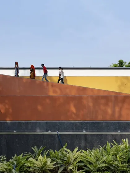 The exterior of the Vismaya museum is a composition of bold, simple forms articulated in different colors and textures. This approach breaks down the building's mass and responds to the surrounding landscape and internal display requirements.