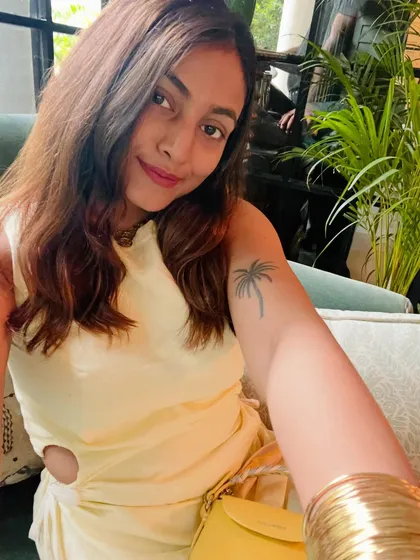A selfie showing the details of this pale yellow cutout dress from Saga by Kinjal. The hemp fabric gives it a unique texture, and the side cutout adds a modern touch.