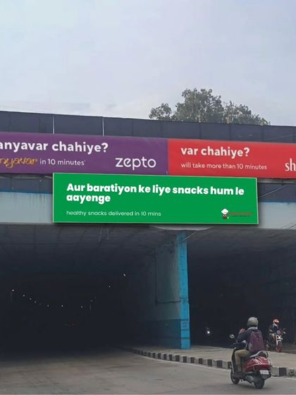 Aur baratiyon ke liye snacks hum le aayenge. This fun billboard shows our partnership with Zepto, promising healthy snacks delivered in just 10 minutes.