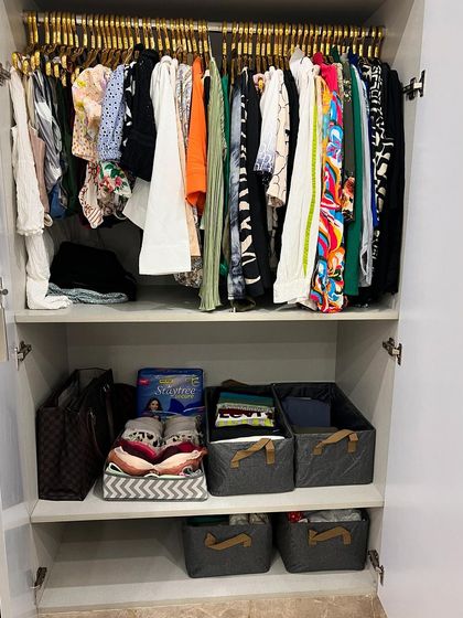 This wardrobe combines hanging space for tops with baskets on the shelves for folded items and accessories, creating a balanced and organized system.